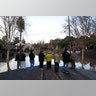 People stand by a flooded street near William Street Park after heavy rains overflowed nearby Coyote Creek in San Jose, California. 