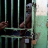 An ailing prisoner stands in a cell designated for sick prisoners near the infirmary in the National Penitentiary in downtown Port-au-Prince, Haiti.