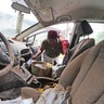 Gillis Leho looks for documents in her car that was covered by floodwaters