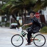A local resident rides a bicycle along an empty street in South Beach