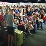 Departing passengers form a long queue to check in at Orlando International Airport 