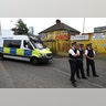 Police officers stand outside a property which was raided in Newham, east London