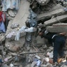 A construction worker searches a building that collapsed