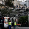 Rescue workers and volunteers search a building that collapsed 