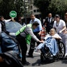 A woman in a wheelchair is evacuated from a clinic 