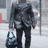 A man covered in snow walks toward the PATH train station terminal, Thursday, Feb. 9, 2017, in Hoboken, N.J. 