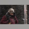 A woman shields her face during a winter storm in Philadelphia, Thursday, Feb. 9, 2017.