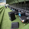 A trash can lays by ripped seats at one of the dugouts in Maracana stadium. 