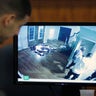 Former New England Patriots player Aaron Hernandez looks on as a still frame from surveillance video is displayed on a monitor during his murder trial.