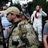 A white supremacist stands behind militia members during a demonstration in Charlottesville, Virginia, August 12 