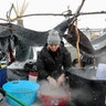 A woman washes dishes in the Oceti Sakowin camp in a snow storm during a protest against plans to pass the Dakota Access pipeline.