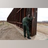 A U.S. Border patrol agent opens a gate on the fence along the Mexico border to allow vehicles pass in El Paso.