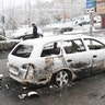 A policeman investigates a burnt car in Rinkeby, February 21, 2017. 