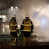 Firefighters are seen as several cars were set on fire during a riot in Rinkeby, outside Stockholm, Sweden.