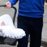 Britain's Prince William carrying his baby daughter in a car seat