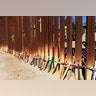 Wooden crosses, in memory of migrants who died crossing to the U.S., lean on the border fence in Nogales, Mexico.