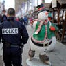 French police officer patrols a Christmas market amid heightened security on the Champs Elysees Avenue in Paris.