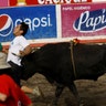 A participant is gored by a bull during a traditional bullfighting festival called 