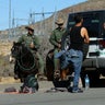 U.S. Border Patrol supervisor Bobby Stine frisks a man a few hundred meters from the U.S.-Mexico border fence near Jacumba, California.