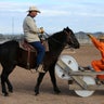 Randy Helm rides a horse, while inmate Gabriel Curtis gestures, as they train a horse as part of the Wild Horse Inmate Program (WHIP) at Florence State Prison in Florence, Arizona.