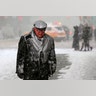 A man walks in Times Square as snow falls in New York.