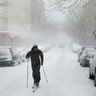 A man uses cross-country skis to travel down a street during a heavy snowstorm in the Brooklyn, New York.