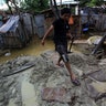 A man walks at his flooded home damaged after heavy rain in Castilla district of  Piura.