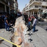 People gather at the site of car bomb attack near a government office in Karkh district in Baghdad