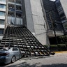 A damaged car is seen outside a building after an earthquake in Mexico City, Tuesday