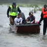 Volunteers from the Civilian Crisis Response Team help rescue three children from their flooded home in James City, North Carolina, Friday