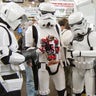 Stormtroopers pose with a bity bot.