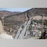 A Border Patrol vehicle drives by the border fence in Tecate, Calif., left, along the metal barrier that lines the border seen from Tecate, Mexico. 