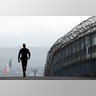 Border Patrol agent Eduardo Olmos walks near the secondary fence separating Tijuana, Mexico, background, and San Diego.