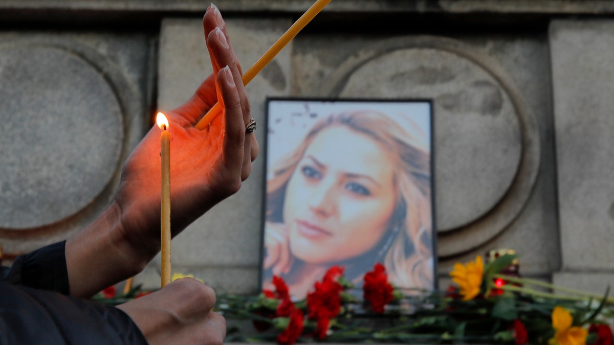 Oct. 8: A woman holds a candle next to a portrait of slain television reporter Viktoria Marinova during a vigil at the Liberty Monument in Ruse, Bulgaria.