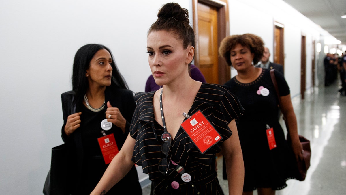 Actress Alyssa Milano walks to a Senate Judiciary Committee hearing after a break on Capitol Hill in Washington, Thursday, Sept. 27, 2018, with Christine Blasey Ford and Supreme Court nominee Brett Kavanaugh.