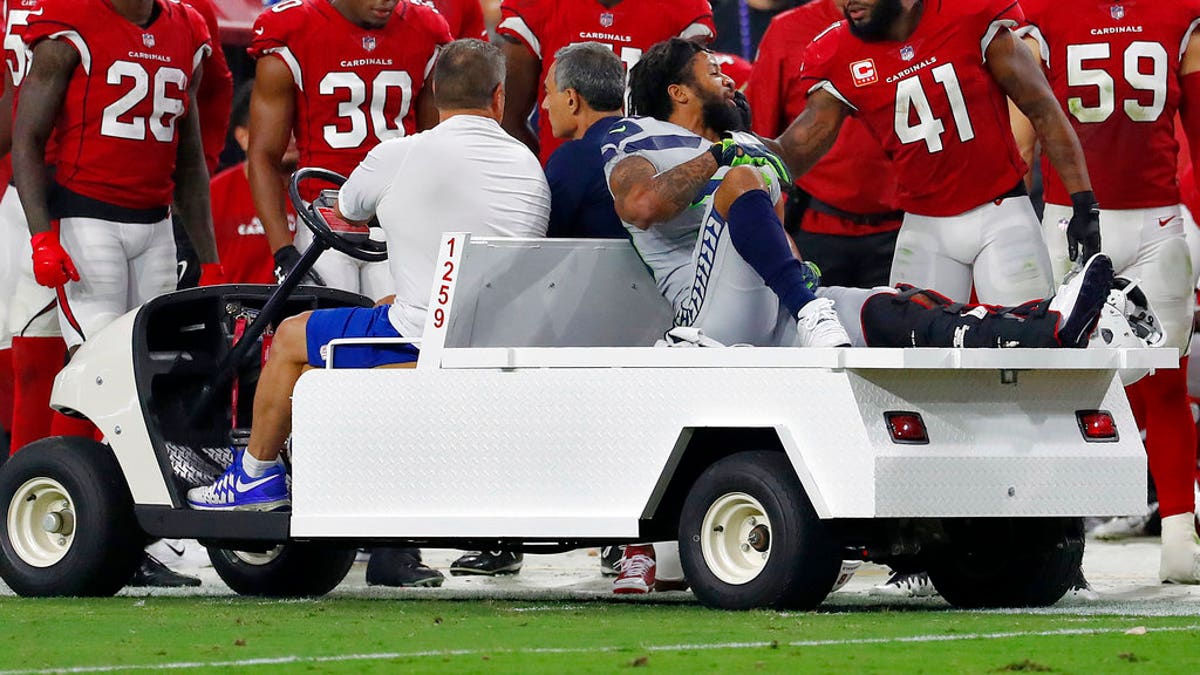 Seattle Seahawks defensive back Earl Thomas is greeted by Arizona Cardinals players as he leaves the field after breaking his leg during the second half of an NFL football game.