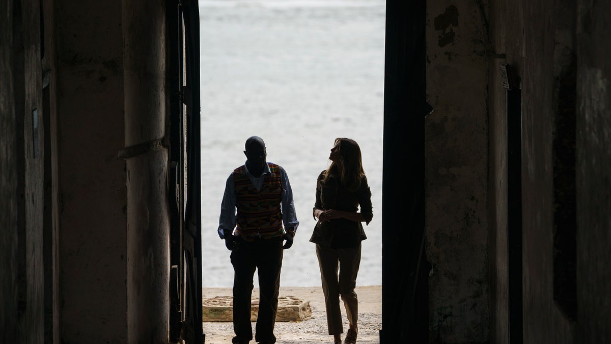 First lady Melania Trump looks up as she walks through the "Door Of No Return" with museum educator Kwesi Essel-Blankson as she visits Cape Coast Castle in Ghana on Oct. 3, 2018. (AP Photo/Carolyn Kaster)