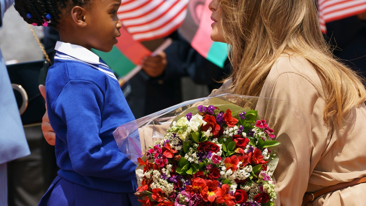 First lady Melania Trump is greeted by a flower girl as she arrives at Lilongwe International Airport, in Lumbadzi, Malawi. (AP Photo/Carolyn Kaster)