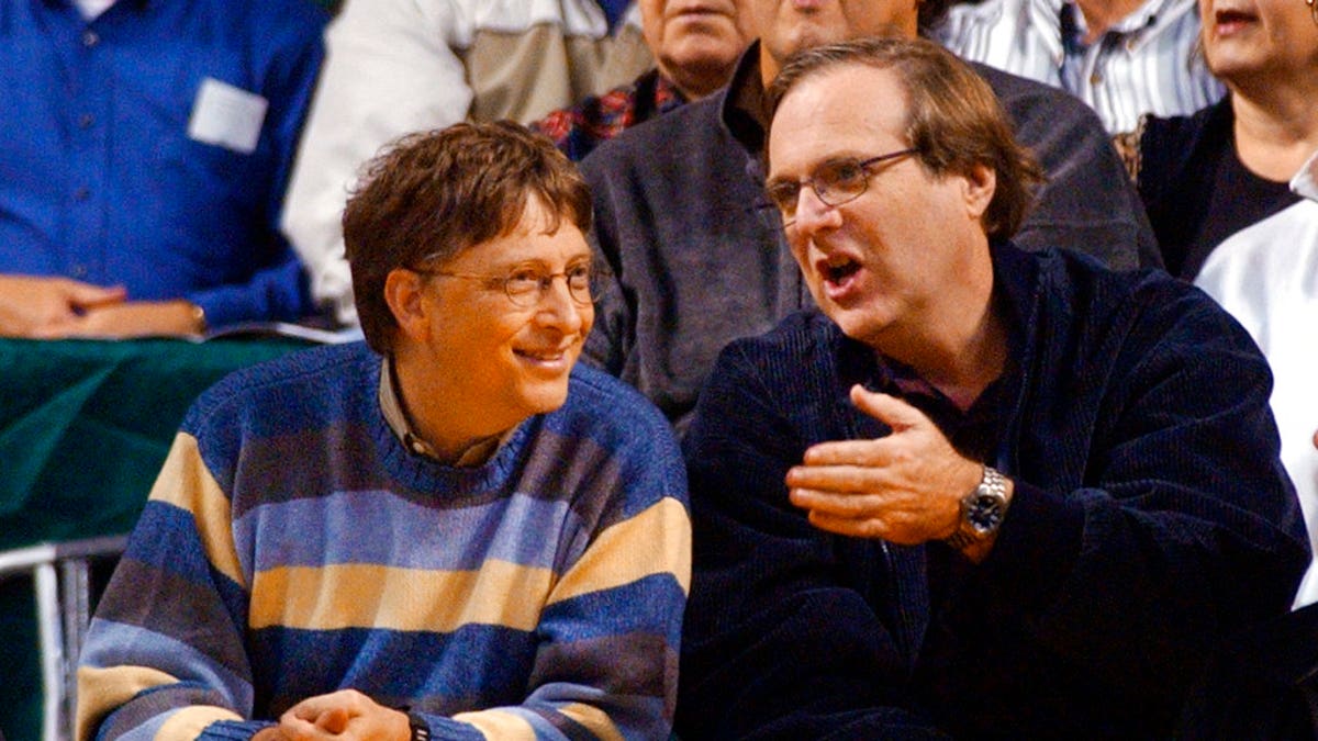 In this March 11, 2003 file photo, Microsoft Chairman Bill Gates, left, chats with Portland Trail Blazers owner and former business partner Paul Allen during a game between the Trail Blazers and Seattle SuperSonics in Seattle.