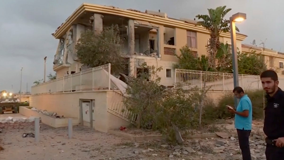 In this image made from video, police inspect the damage to a building from a rocket, Wednesday, Oct. 17, 2018, in Beersheba, Israel. The Israeli military says a rocket fired from Gaza made a direct hit on a home in southern Israel.