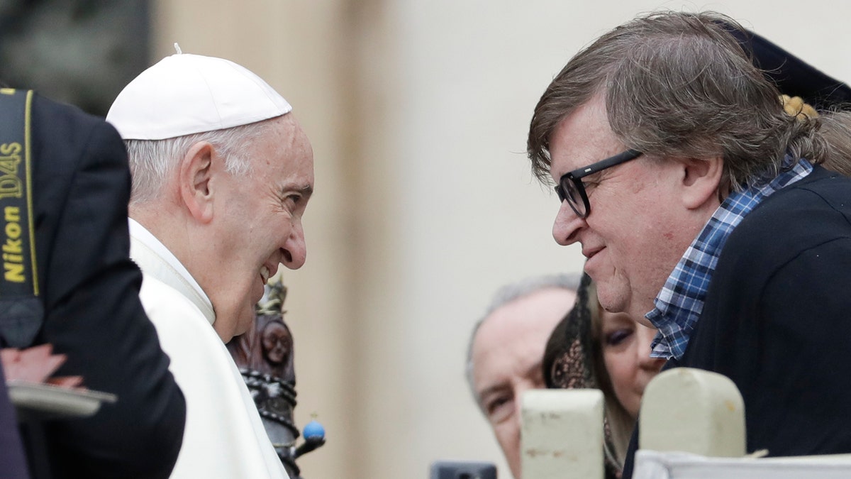 Pope Francis talks with director Michael Moore during his weekly general audience, in St. Peter's Square, at the Vatican, Wednesday, Oct. 17, 2018.