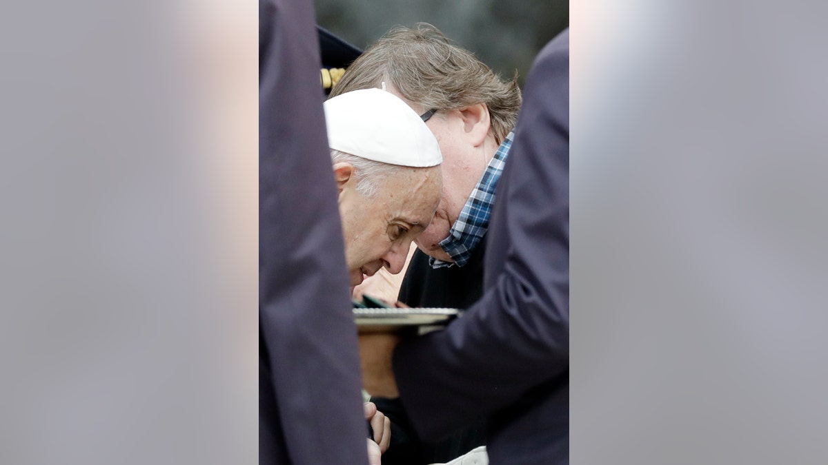 Pope Francis talks with director Michael Moore during his weekly general audience, in St.Peter's Square, at the Vatican, Wednesday, Oct. 17, 2018.