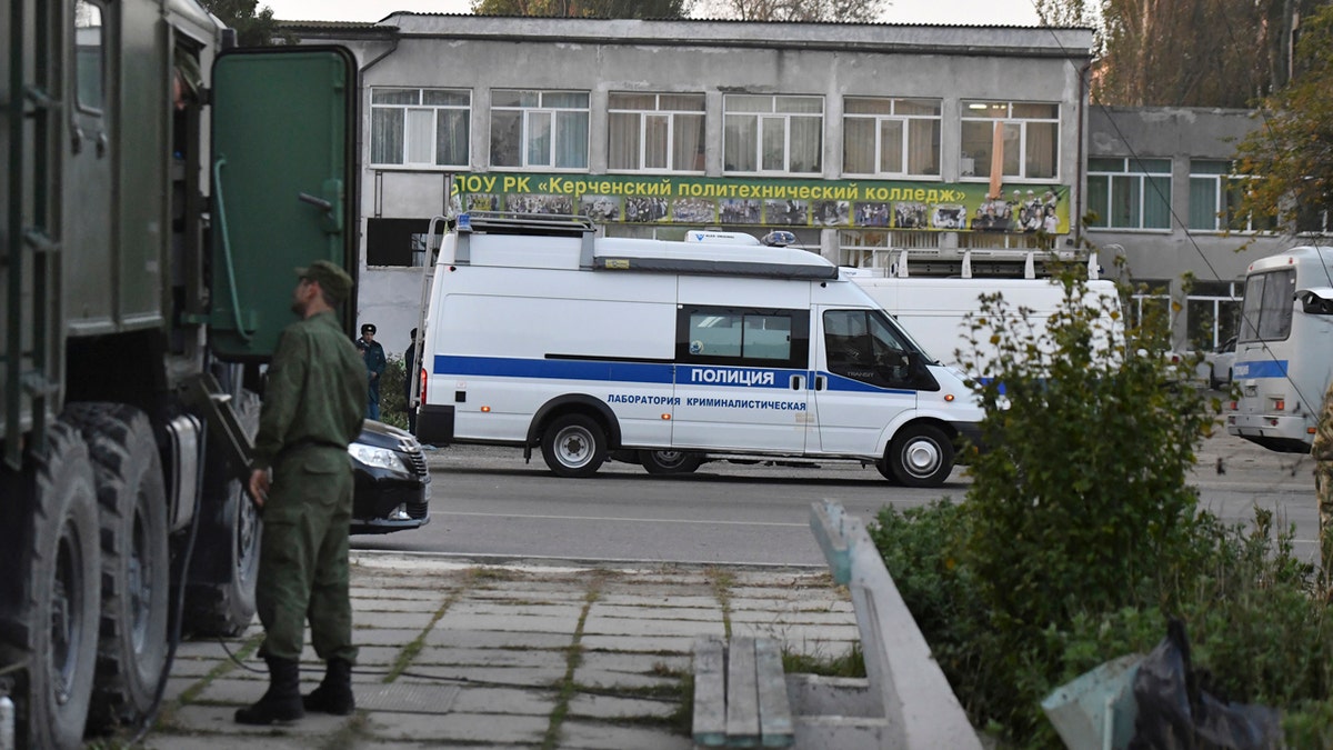 Police vehicles are parked near a vocational college in Kerch, Crimea, Thursday, Oct. 18, 2018.