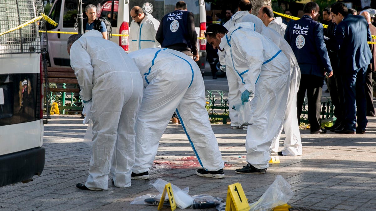Tunisian forensic experts work on the scene of an attack after a 30-year-old woman blew herself on the Habib Bourguiba avenue in Tunis, Tunisia. (AP Photo/Riadh Dridi)
