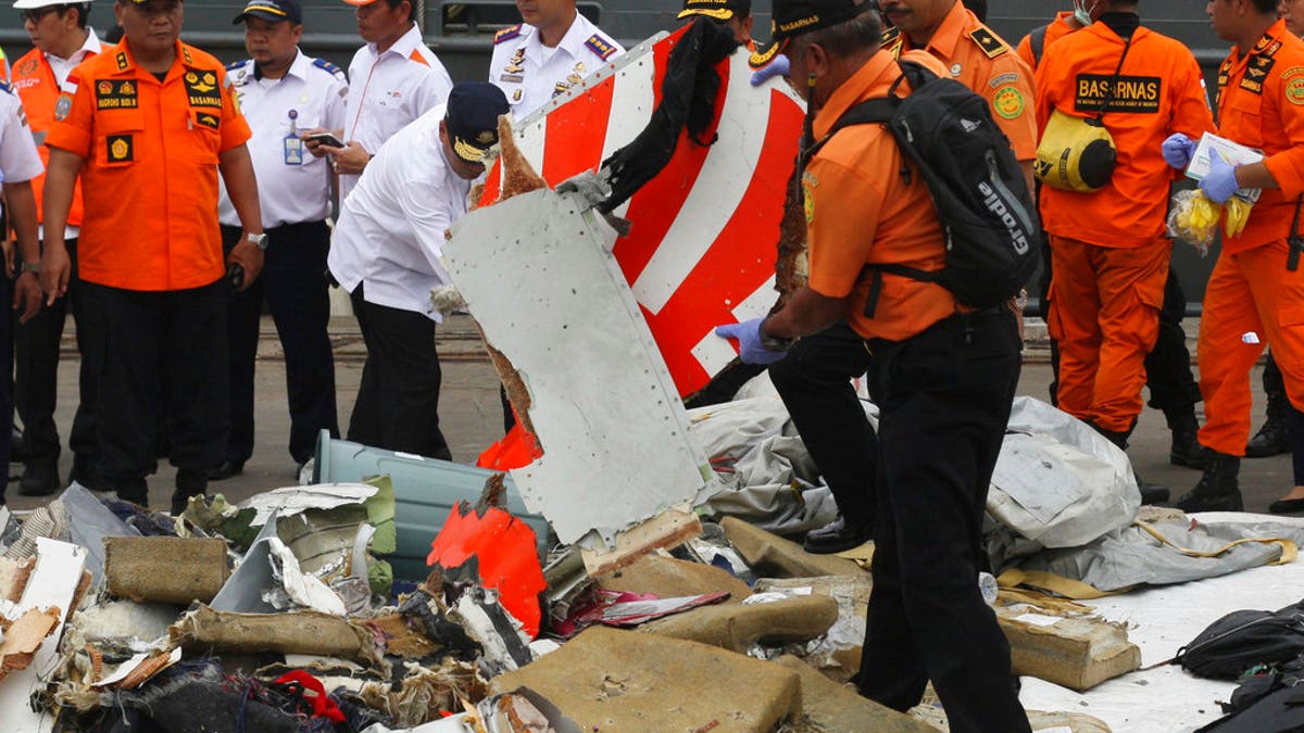 FILE: A rescuer inspects a part of Lion Air plane flight JT 610 retrieved from the waters where it's believed to have crashed at Tanjung Priok Port in Jakarta, Indonesia, Tuesday.
