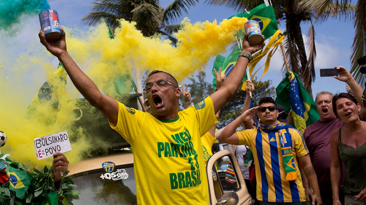 Supporters of Jair Bolsonaro singing the national anthem in front of his house during the presidential runoff election in Rio de Janeiro, Brazil, on Sunday. (AP Photo/Silvia Izquierdo)