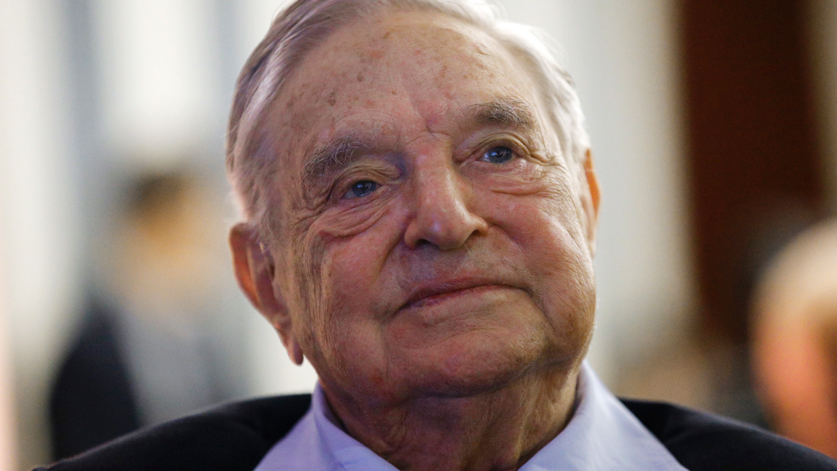 George Soros wearing blue collared shirt