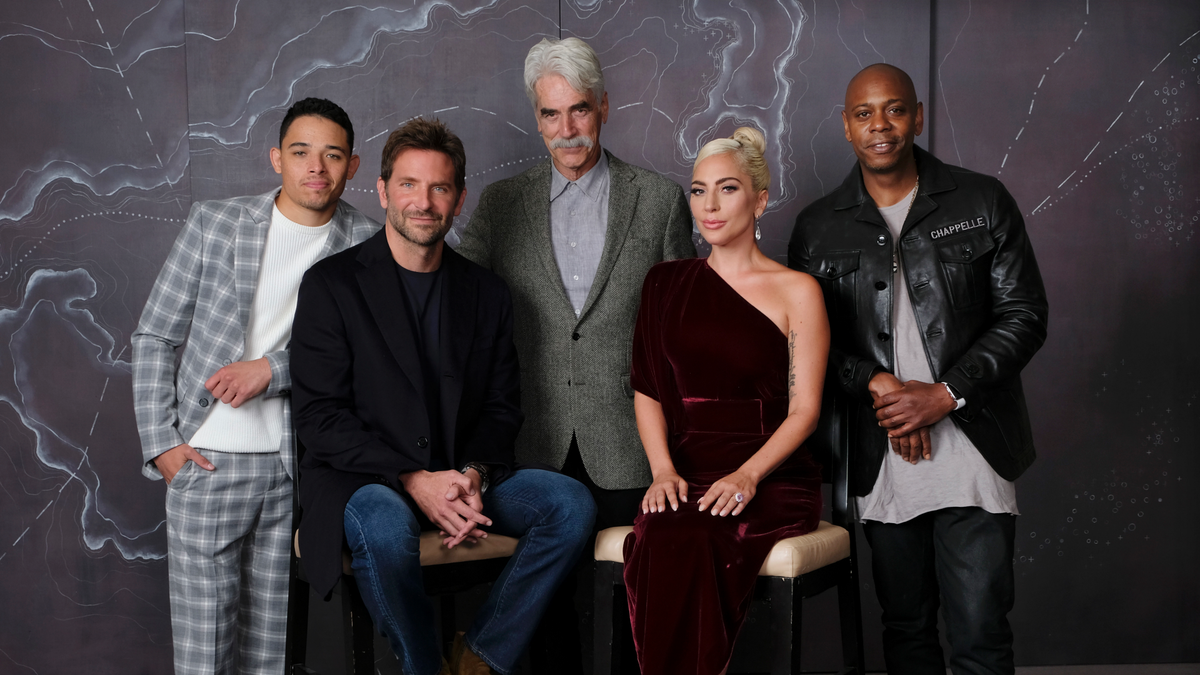 In this Sept. 9, 2018 photo, Bradley Cooper, seated left, cast member and director of the film "A Star is Born," poses with actors, from left, Anthony Ramos, Sam Elliott, Lady Gaga and Dave Chappelle at the Four Seasons Hotel during the Toronto International Film Festival in Toronto. The film opens in theaters on Friday, Oct. 5. (Photo by Chris Pizzello/Invision/AP)