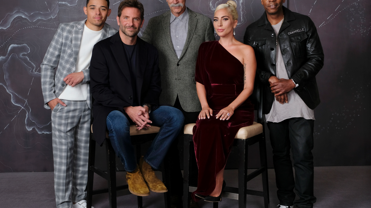 In this Sept. 9, 2018 photo, Bradley Cooper, seated left, cast member and director of the film "A Star is Born," poses with actors, from left, Anthony Ramos, Sam Elliott, Lady Gaga and Dave Chappelle at the Four Seasons Hotel during the Toronto International Film Festival in Toronto. The film opens in theaters on Friday, Oct. 5. (Photo by Chris Pizzello/Invision/AP)