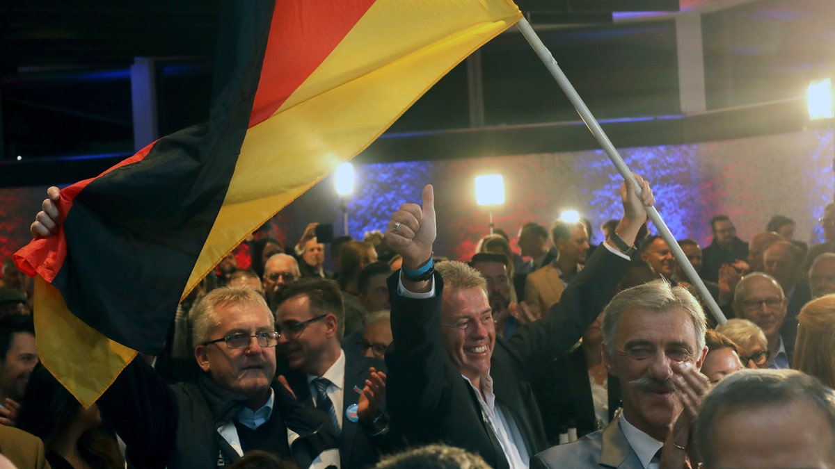 Supporters of the nationalist Alternative for Germany AfD celebrate after the state election in the German state of Hesse in Wiesbaden, western Germany, Sunday, Oct. 28, 2018. Exit polls show Chancellor Angela Merkelâ€™s party leading with a significant drop in support for both her conservatives and their center-left partners in the national government. (Frank Rumpenhorst/dpa via AP)